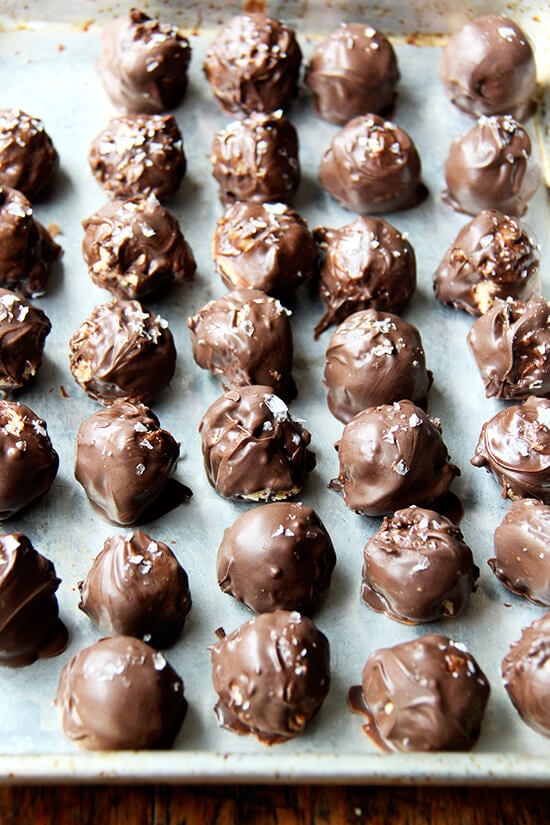 These chocolate-covered peanut butter balls are truly delicious! This recipe, with a little bit of practice and patience (the whole process is sort of a long affair) is actually fairly easy and very rewarding. I've discovered another beautiful homemade gift for the holidays that I am really looking forward to giving to friends...a lot of friends: the recipe makes 165! // alexandracooks.com A sheet pan of chocolate-covered peanut butter balls.