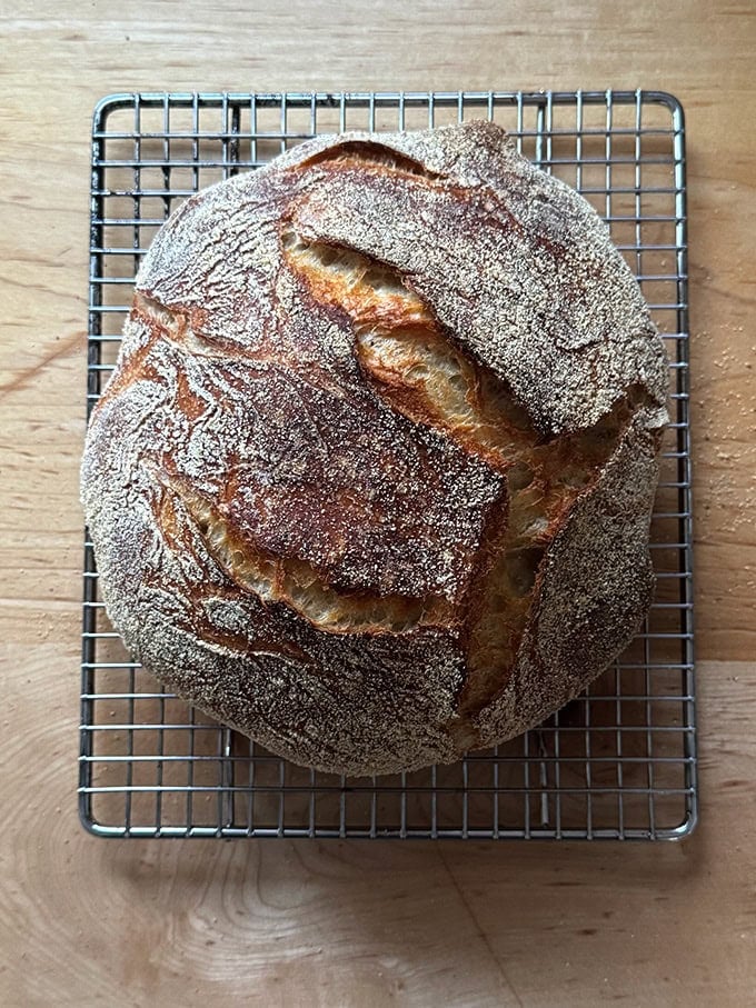 A loaf of Jim Lahey's no-knead bread on a cooling rack.