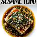 A bowl of tofu with spicy sesame scallion sauce aside spicy broiled broccoli.