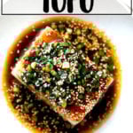 A bowl of tofu with spicy sesame scallion sauce aside spicy broiled broccoli.