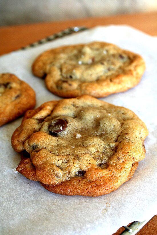 chewy chocolate chip cookie with a touch of salt on top A sheet pan with freshly baked chocolate chip cookies.