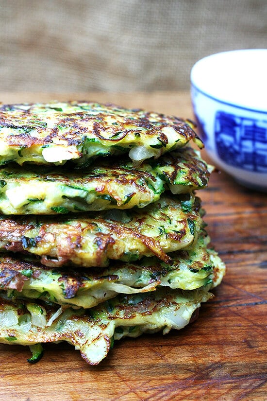 A combination of grated zucchini and potato with a little diced onion give these zucchini fritters a lovely latke texture. But the addition of lemon zest and lots of herbs give them a freshness and lightness that's irresistible. // alexandracooks.com a stack of zucchini fritters
