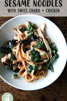 A bowl of sesame noodles with swiss chard.