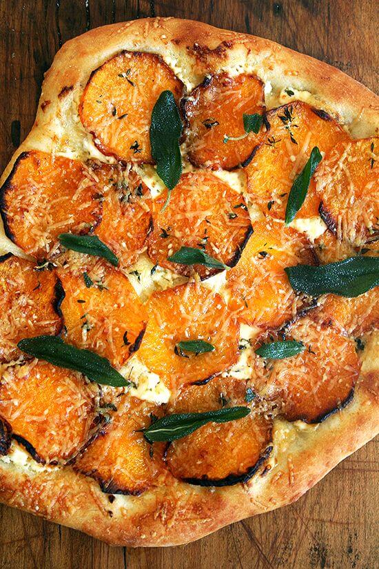 Garlic oil, homemade ricotta, roasted butternut squash, fresh thyme and crispy sage, this butternut squash and crispy sage pizza captures fall in every bite. What's more? The dough takes no more than five minutes to prepare. Happy fall! // alexandracooks.com A roasted butternut squash and crispy sage pizza on a board.