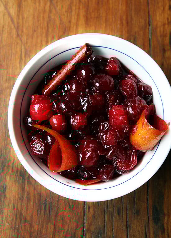 A touch more sophisticated than the traditional Thanksgiving condiment, this cranberry sauce, made with red wine, orange zest and cinnamon sticks, is simple to prepare. // alexandracooks.com An overhead shot of a bowl holding homemade red wine cranberry sauce with orange zest and cinnamon.