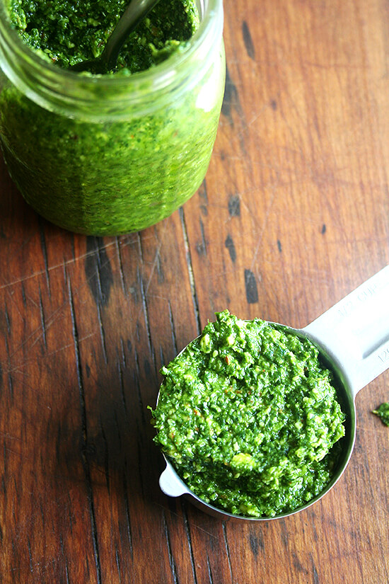 pesto A measuring cup filled with pesto sauce aside a jar of homemade pesto sauce.