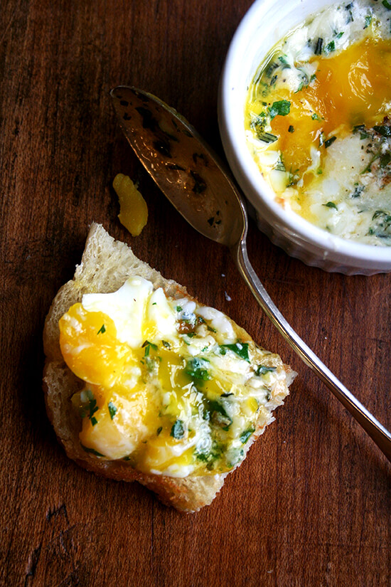This recipe for baked eggs appeared in the New York Times Magazine in 1985, and my mother has been making them for us ever since. Topped with herbs — parsley, sage, rosemary and thyme — melted gruyère and a few splashes of Tabasco, these perfectly soft-cooked eggs are such a treat. // alexandracooks.com A piece of toast topped with baked (shirred) eggs.