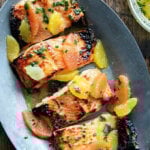 A sizzle platter holding filets of arctic char + citrus sauce.