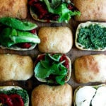 A board of roasted red pepper, mozzarella, and basil pesto sandwiches.