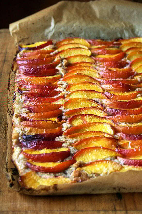 For this peach frangipane tart, my favorite galette dough is used for a sheet-pan tart. After smearing the whole batch of frangipane over its surface and arranging half a dozen sliced peaches over top, the fruit is brushed with melted butter and sprinkled with sugar. Forty minutes later, the tart emerges from the oven, slices of fruit glistening, frangipane bubbling through the crevices. // alexandracooks.com For this peach frangipane tart, my favorite galette dough is used for a sheet-pan tart. After smearing the whole batch of frangipane over its surface and arranging half a dozen sliced peaches over top, the fruit is brushed with melted butter and sprinkled with sugar. Forty minutes later, the tart emerges from the oven, slices of fruit glistening, frangipane bubbling through the crevices. // alexandracooks.com
