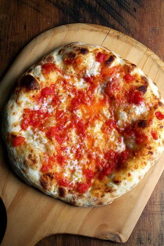 Just-baked Margherita pizza on a pizza peel.