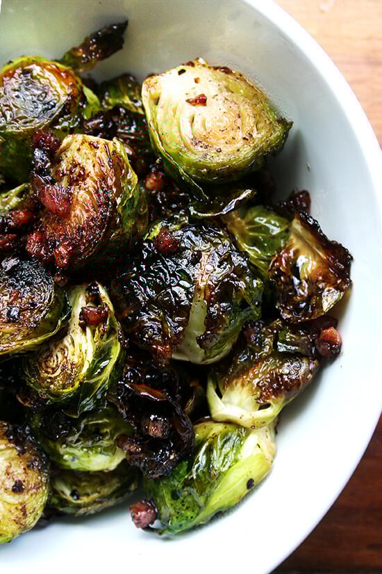 Roasted with olive oil, salt and pepper, the Brussels sprouts and the pancetta crisp up in unison, the fat from the pancetta flavoring the sprouts, whose crispy surfaces emerge glistening and caramelized. Served with balsamic vinegar, this is a Brussels sprouts recipe that even those who don't like sprouts will absolutely love! // alexandracooks.com Overhead close-up of brussel sprouts roasted with olive oil, salt and pepper, and crispy pancetta in a white serving bowl.