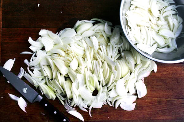 6 pounds of sliced onions on a board.