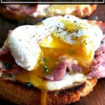 Croque madame — croque monsieur topped with a poached egg — on a cutting board.