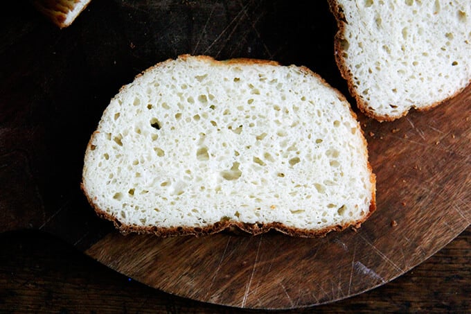 A slice of gluten-free peasant bread on a board.