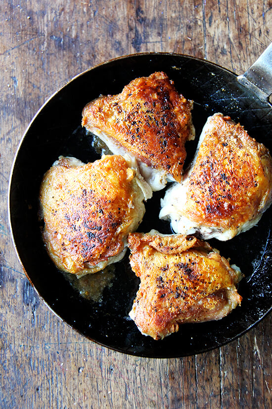 How can salt, pepper and preserved lemon alone produce such a delicious chicken with preserved lemon? Why have I never used this method — 30 minutes skin side down, 10 minutes skin side up — to cook thighs? How can such a simple method create the crispiest skin, the juiciest meat? You have to try it for yourself! // alexandracooks.com A skillet filled with crispy chicken thighs.