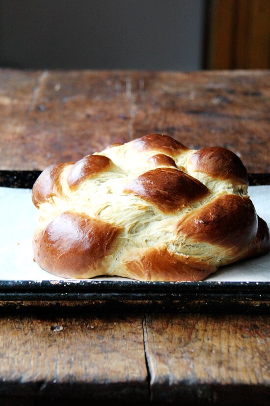 This simple challah rises beautifully and bakes into a perfectly golden, light and airy, tangle of braids. I like to make this often as a treat aside any soup and a treasure for weekend brunch.// alexandracooks.com Just-baked challah bread on a sheet pan.