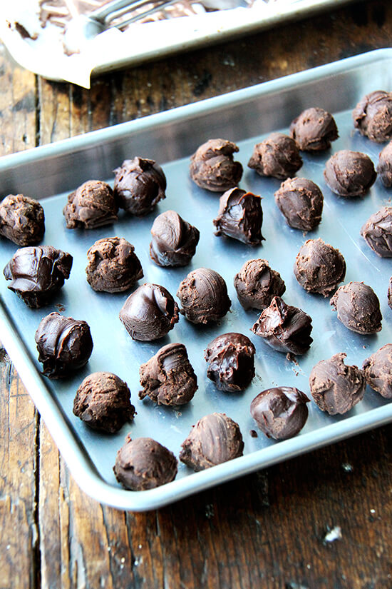 Chocolate truffles make a simple dessert, an elegant homemade gift, a festive treat to break out at impromptu gatherings. One batch, which yields at least 3 dozen, can be made days in advance and stored in the fridge. Easy to make and pretty to boot, what's not to love? // alexandracooks.com Scooped chocolate truffles on a sheet pan.