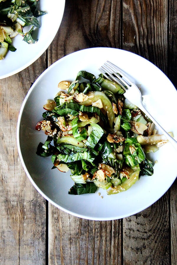 Bok choy salad is excellent as its crunchy stalks and sturdy leaves are capable of enduring a bold, salty-sweet dressing. A slightly sweet dressing, in fact, is just what slightly bitter bok choy needs. The most fun part about this recipe, however, is the sesame-almond crunch, a mix of melted sugar, toasted almonds and sesame seeds, that comes together in a flash and disappears about as quickly. // alexandracooks.com Bok choy salad with sesame almond crunch in a salad bowl.