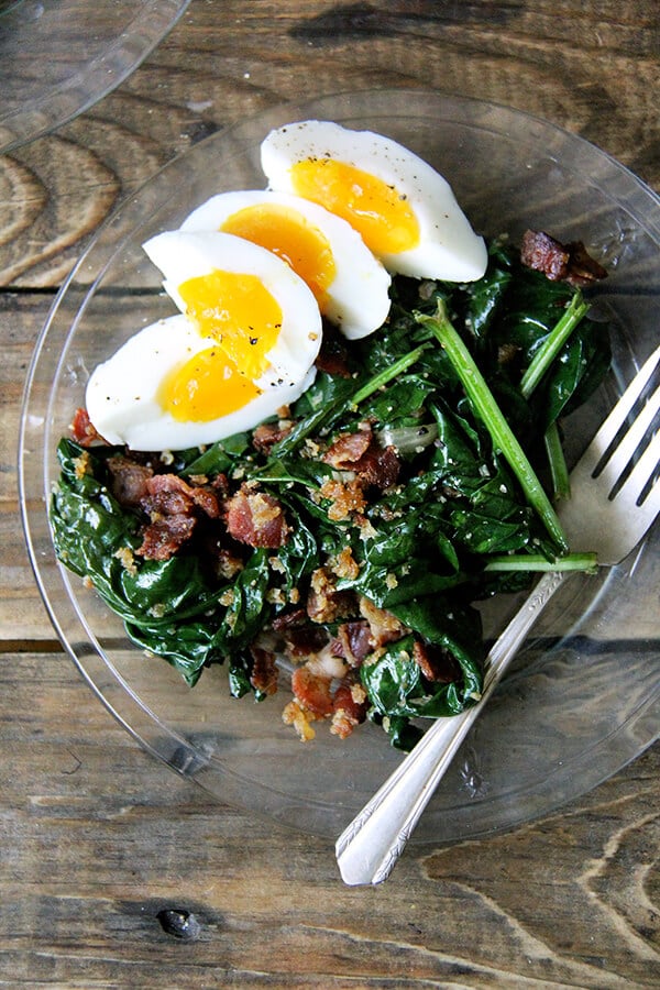 This warm spinach salad calls for gently wilting the spinach in a stainless steel bowl set over simmering water. Cool, right? And bacon and breadcrumbs make everything better. Am I right? // alexandracooks.com A plate of warm spinach salad with bacon and bread crumbs.