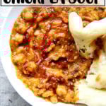 Moroccan chickpea stew, aka Leblebi, on a table with bread and harissa.