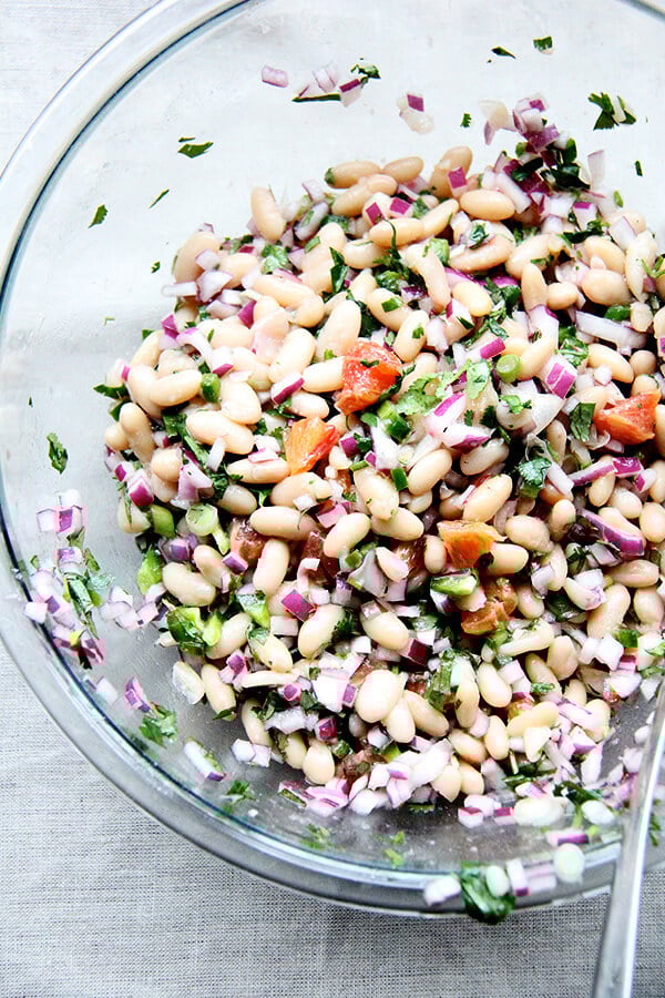 We've been eating this white bean and orange salsa, mixed with onions, lime, jalapeƱos, cilantro, and orange, with chips, but it would be nice tucked inside a taco or a burrito or aside spicy wings and nachos and anything else you might find yourself surrounded by on game day. // alexandracooks.com A large bowl of white bean and orange salsa.
