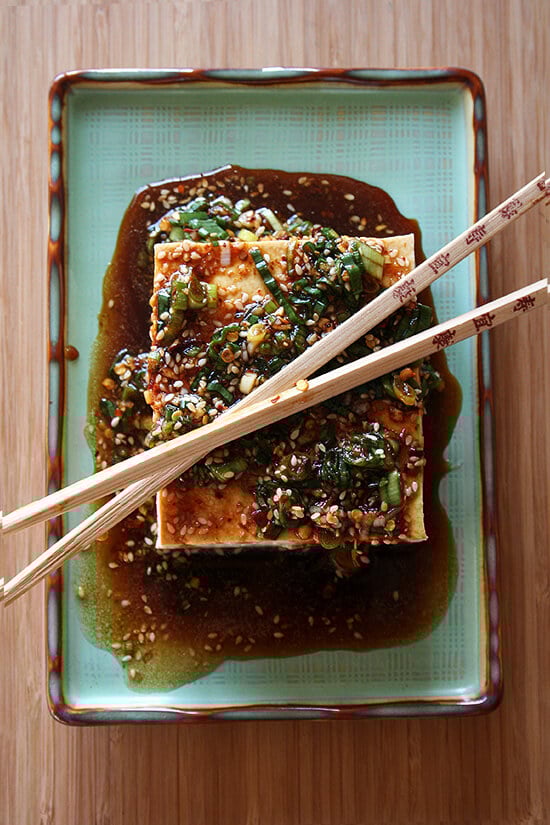 This baked tofu has a simple preparation, which calls for making a four-ingredient dressing, and results in nicely textured and completely tasty tofu—crispy edges, custardy centers, sesame-soy flavor throughout. // alexandracooks.com Tofu with sesame sauce on a platter.