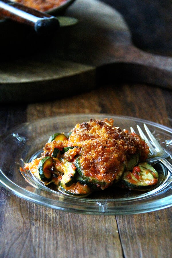 If you're looking for zucchini recipes to help you cull your zucchini crops down, this recipe for zucchini parmesan will fit the bill! Roasting zucchini rounds for 10 minutes, then layering them with homemade sauce and parmesan cheese and finishing it off with a breadcrumb topping. Simple but delicious! // alexandracooks.com a plate of zucchini parmesan