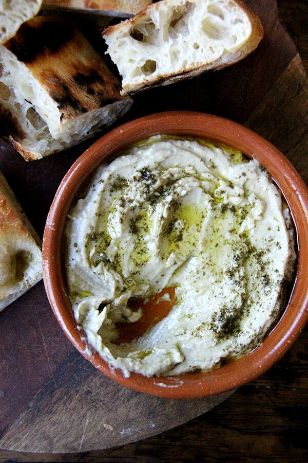 This smoky eggplant dip calls for charring whole eggplant on a grill or over an open flame until the skin is blackened. The rest is easy: pulse the eggplant flesh in a food processor with tahini, Greek yogurt, salt, and fresh lemon, and before serving, drizzle with olive oil and sprinkle with za'atar. Yum. // alexandracooks.com This smoky eggplant dip calls for charring whole eggplant on a grill or over an open flame until the skin is blackened. The rest is easy: pulse the eggplant flesh in a food processor with tahini, Greek yogurt, salt, and fresh lemon, and before serving, drizzle with olive oil and sprinkle with za'atar. Yum. // alexandracooks.com