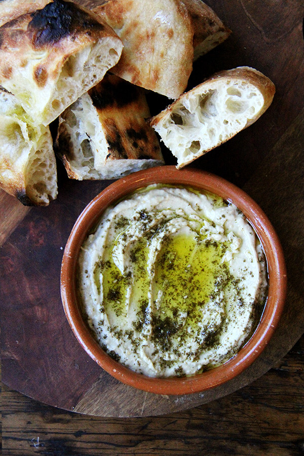This smoky eggplant dip calls for charring whole eggplant on a grill or over an open flame until the skin is blackened. The rest is easy: pulse the eggplant flesh in a food processor with tahini, Greek yogurt, salt, and fresh lemon, and before serving, drizzle with olive oil and sprinkle with za'atar. Yum. // alexandracooks.com This smoky eggplant dip calls for charring whole eggplant on a grill or over an open flame until the skin is blackened. The rest is easy: pulse the eggplant flesh in a food processor with tahini, Greek yogurt, salt, and fresh lemon, and before serving, drizzle with olive oil and sprinkle with za'atar. Yum. // alexandracooks.com