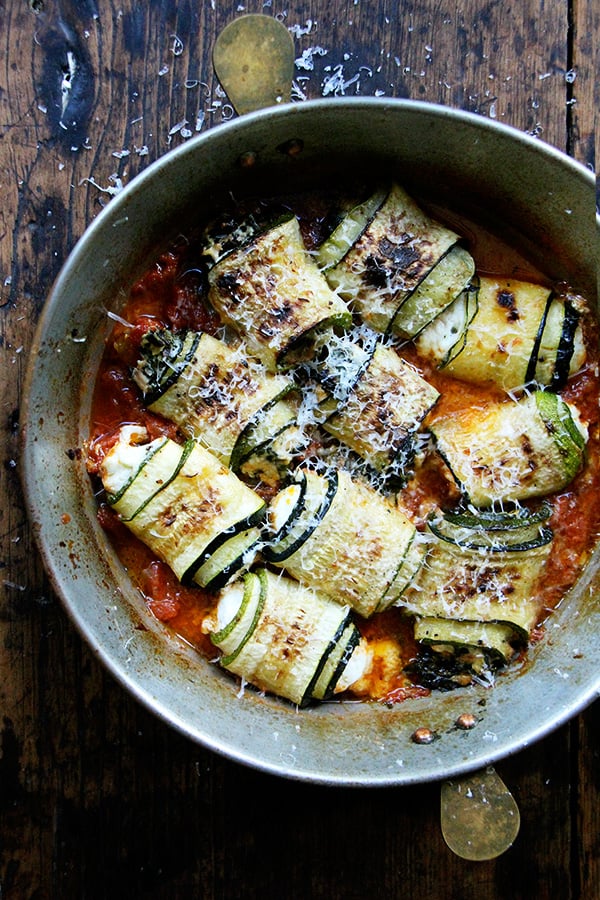 In this zucchini involtini, the ricotta filling is mixed with sautéed chard and lemon zest, but I've had success using leftover fresh corn polenta, chopped up roasted red peppers, and cubes of mozzarella, which makes me think the possibilities for involtini are endless. // alexandracooks.com A pan of zucchini involtini.