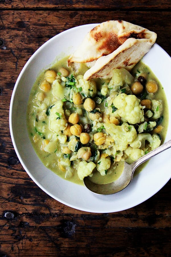 These curried chickpeas come together quickly if you have the chickpeas cooked ahead of time: sauté aromatics, add cooked legume or uncooked lentil (or quick-cooking grain), simmer everything in a mix of coconut milk and water. It's simple and delicious. Healthy, too. // alexandracooks.com A bowl of curried chickpeas and cauliflower.