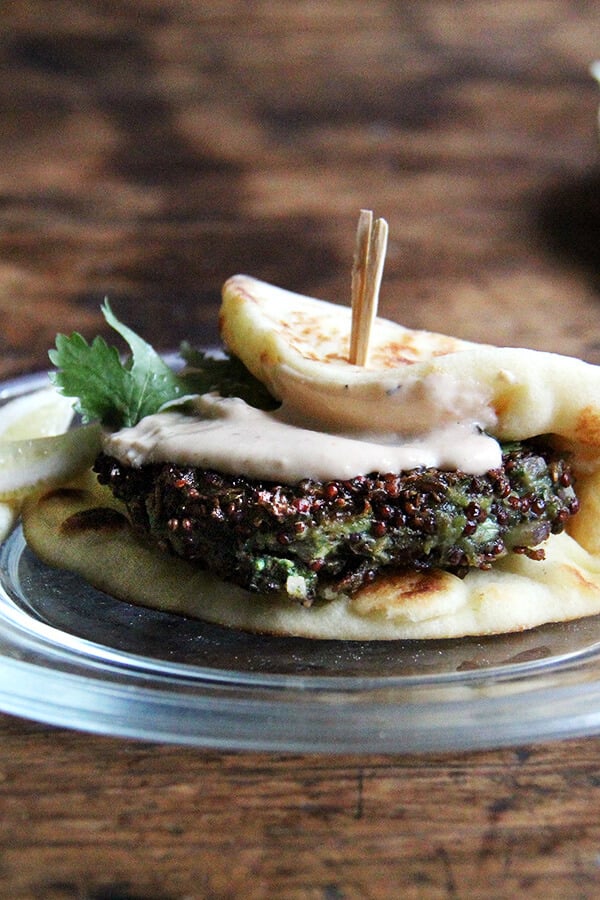 This crispy quinoa cakes can be adapted endlessly—use chard, kale, broccoli rabe, etc. in place of the mustard greens. I like serving them with naan and a yogurt-tahini sauce. The cooked patties are so nice to have on hand—I find myself snacking on them all day—and the "batter" can be prepared ahead of time, stored in the fridge, and baked or fried as needed. // alexandracooks.com A plate of a crispy quinoa cake.