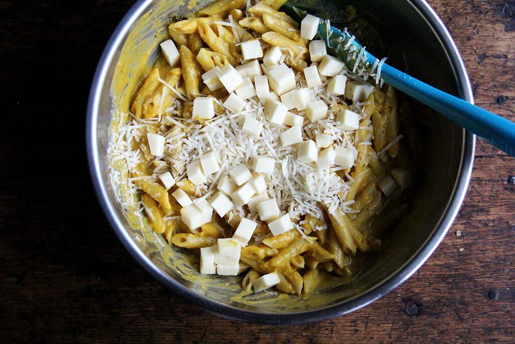 A large bowl with penne, butternut squash sage sauce, and cheese.