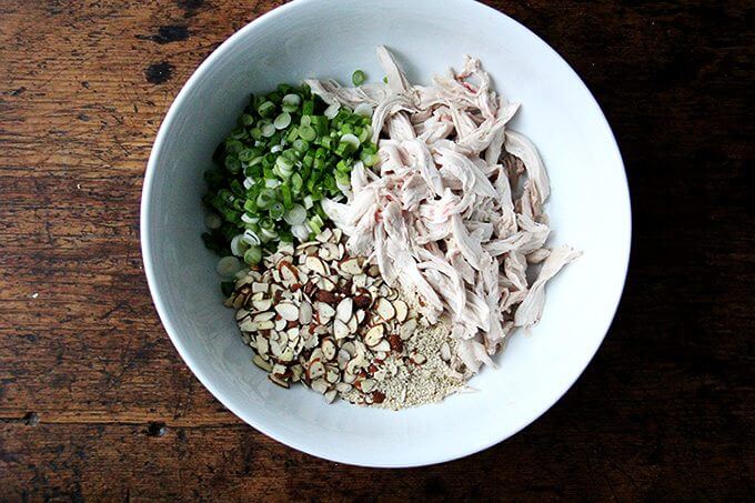Components of chicken and cabbage salad in a bowl.