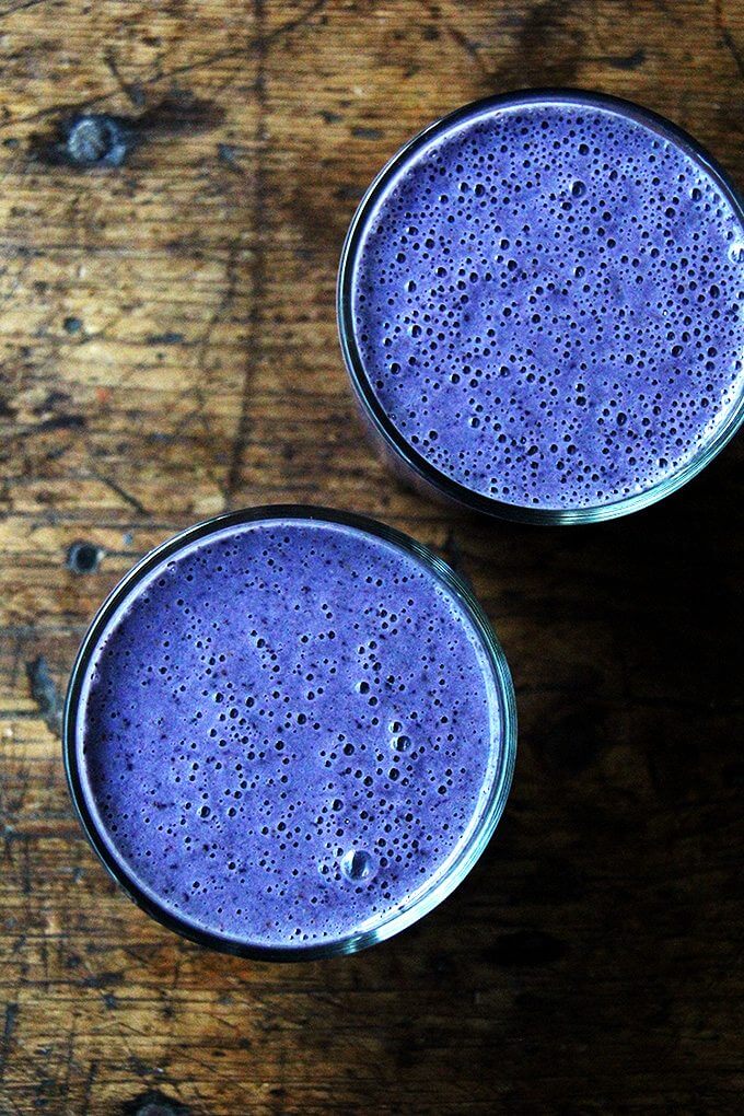 An overhead shot of two blueberry-almond smoothies.