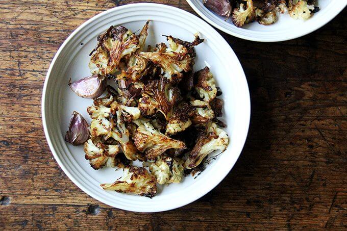 Oven-roasted cauliflower florets in a white bowl.