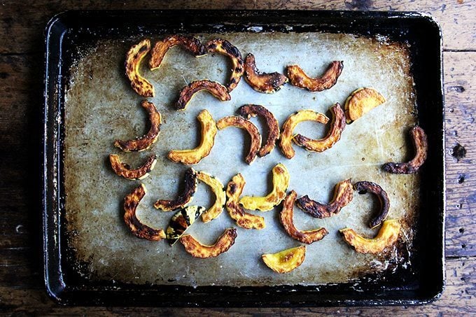 Roasted delicata squash on a sheet pan.
