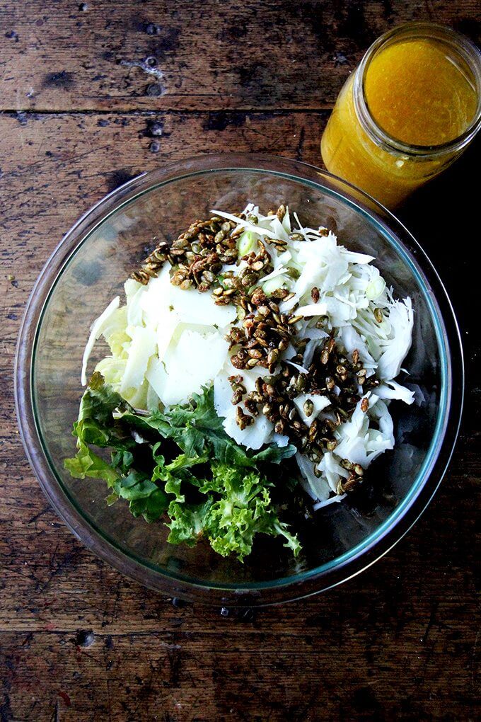 I don't think a fall salad needs to be anything more than greens plus a light dressing, but if you're up for taking it a step further, this is an irresistible option. // alexandracooks.com A large bowl with ingredients for a fall salad with dressing in a jar on the side.