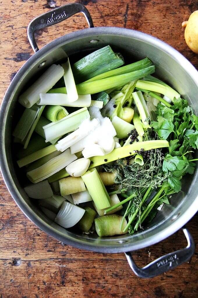 With soup season here, I thought it would be nice to give the vegetable stock recipe I love its own post. Here it is! It takes 45 minutes and will yield 2 quarts of flavorful broth to use in all of your favorite soups in the months ahead. // alexandracooks.com A pot of vegetables ready to be simmered into vegetable stock.