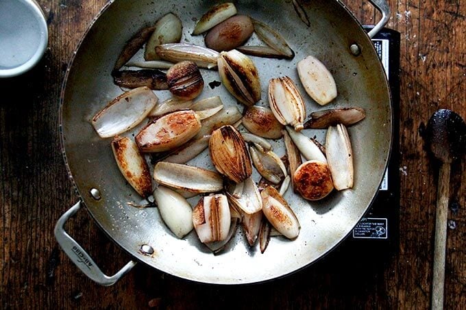 Browned shallots in a skillet.