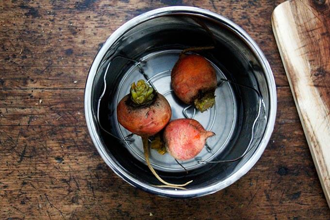 Instant pot with 3 golden beets in it.
