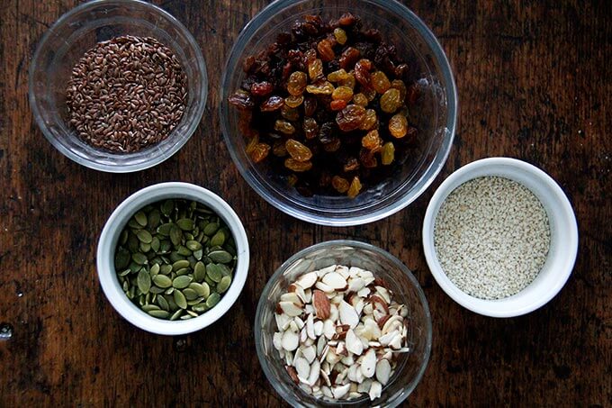 Three seeds, almonds, and golden raisins in a bowl.