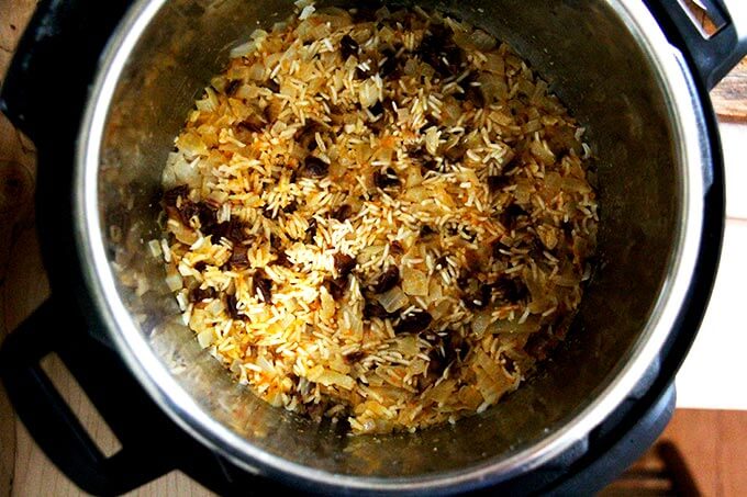 An overhead shot of just-cooked Moroccan rice with dates and orange.