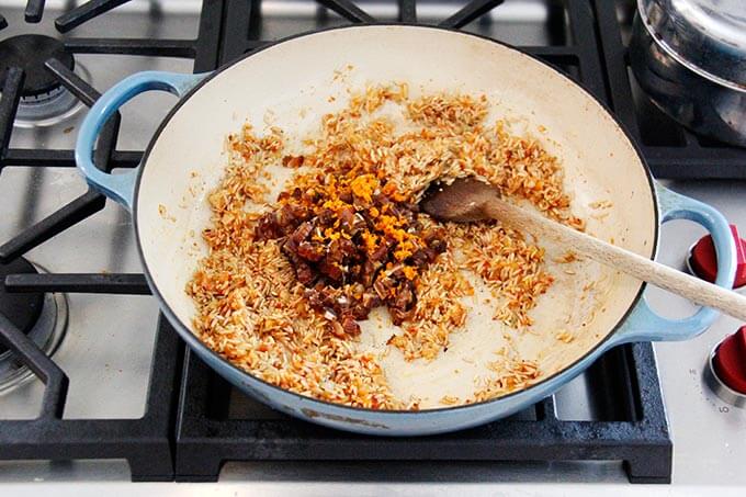 A skillet with Moroccan rice, dates and orange.