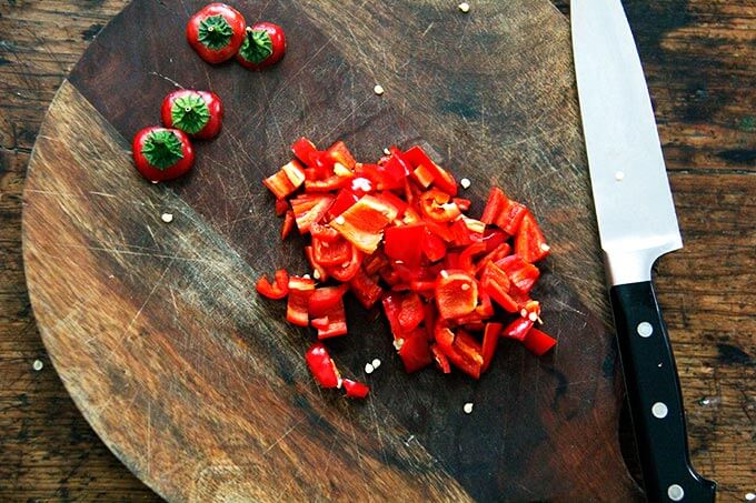 A cutting board with chopped hot chilies.