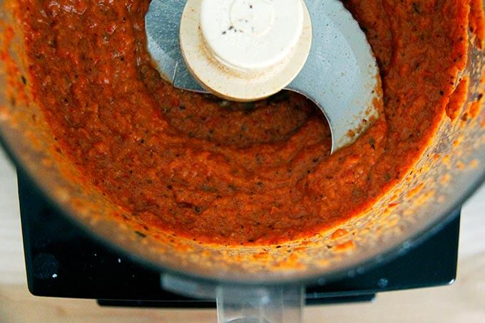 A food processor of puréed homemade harissa paste.