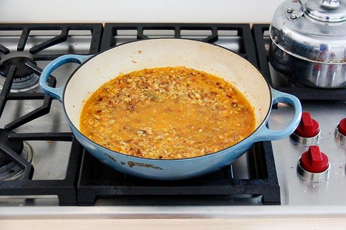 Moroccan rice in a skillet, ready to be covered and simmered.