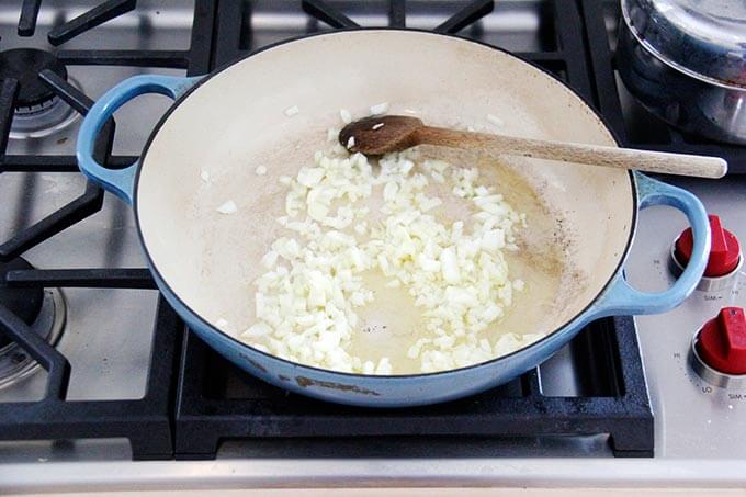 A skillet with a sautéed onion.