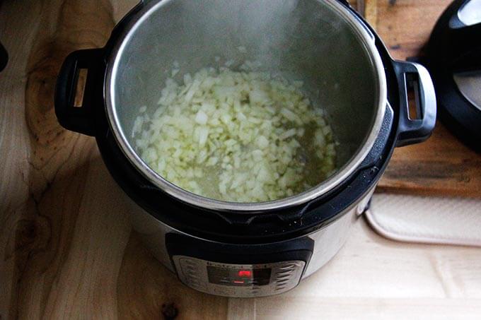An overhead shot of an Instant Pot sautéing an onion.